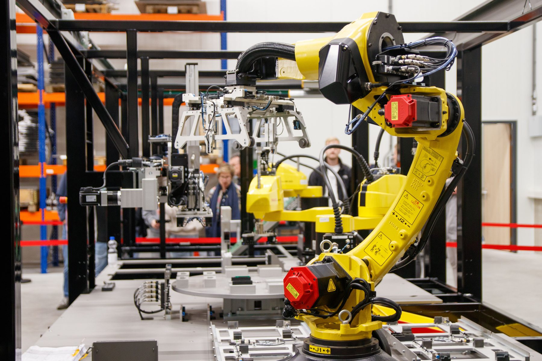 Robotic arm end-of-arm tooling on a manufacturing line
